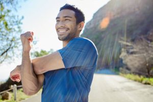 low testosterone and joint pain — man stretching before a workout to protect achy joints