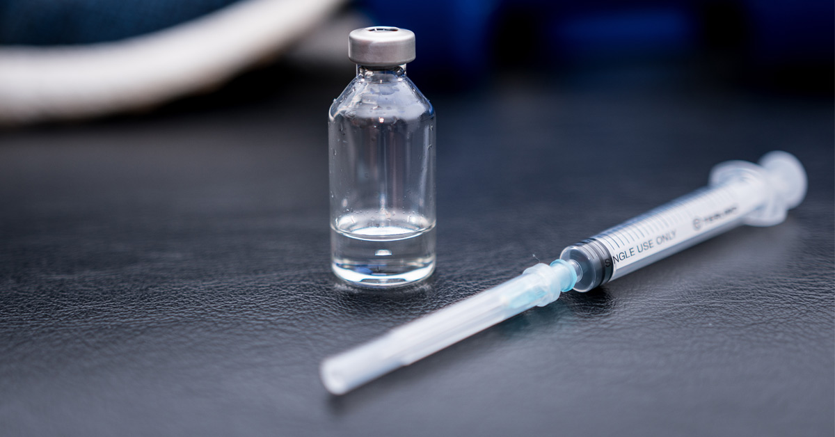 testosterone injection frequency syringes and vial on clinical surface